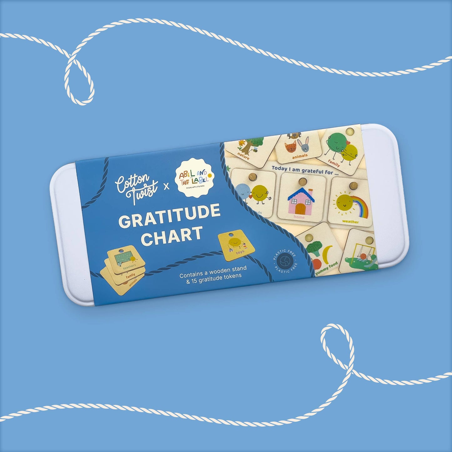 Retail packaging for the 'Cotton Twist x ABL Long Live The Lab' Gratitude Chart craft kit. The blue box shows the wooden stand and several feeling tokens, confirming it 'Contains a wooden stand & 16 feeling tokens,' with illustrations for Home, Family, and Rainbow visible.