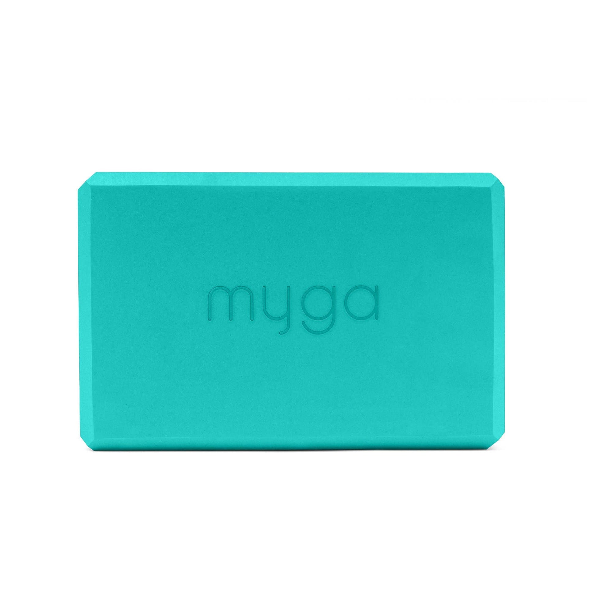 Turquoise yoga block with 'myga' branding on a white background