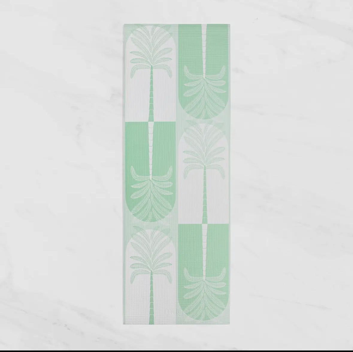 An overhead view of a mint green and white patterned yoga or fitness towel, featuring a repeated design of palm fronds and arches. The towel is laid flat on a white marble-style background.
