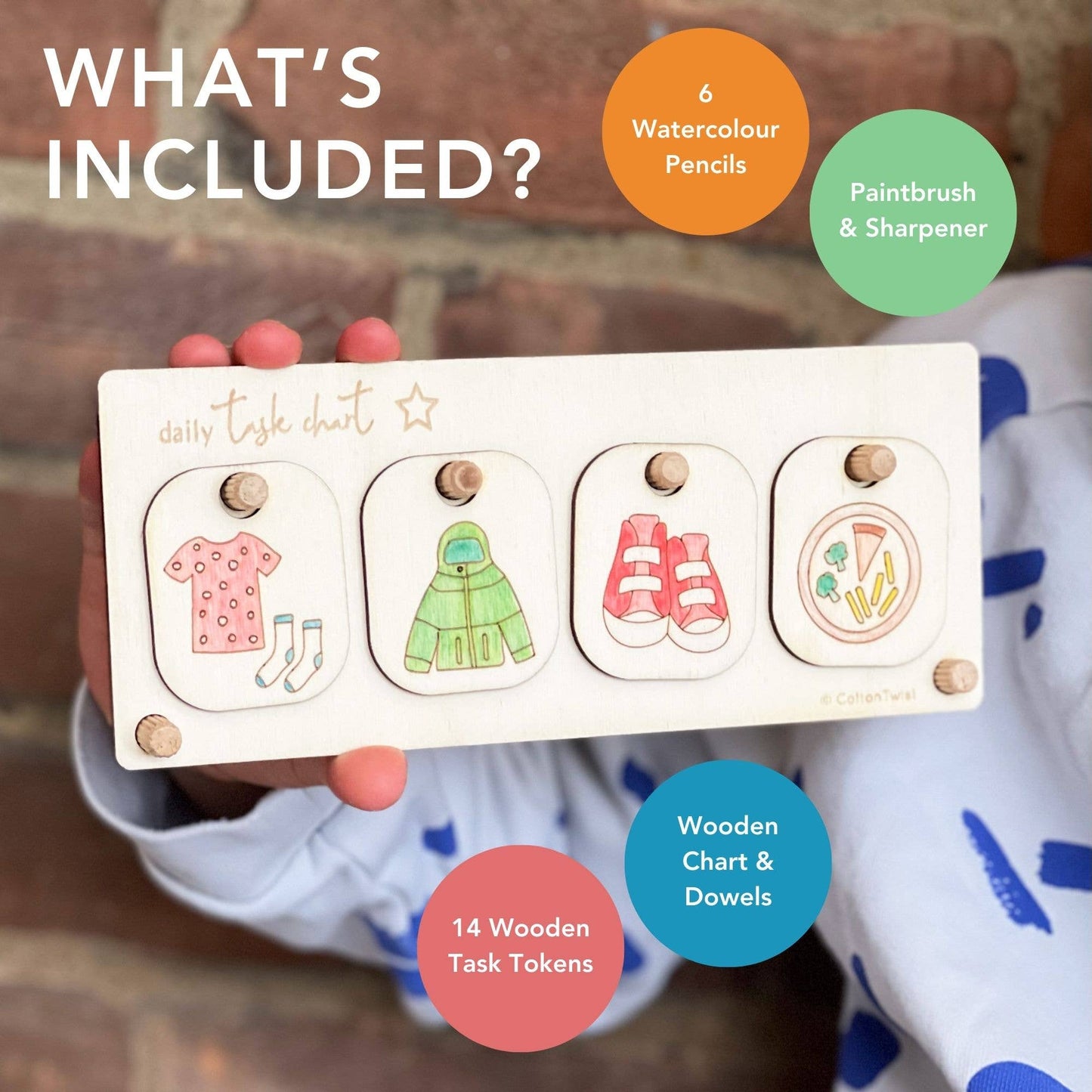 Marketing graphic titled 'WHAT'S INCLUDED?' for the DIY Daily Task Chart kit. The image highlights the contents over the finished display: 6 Watercolour Pencils, Paintbrush & Sharpener, 14 Wooden Task Tokens, and the Wooden Chart & Dowels. A child holds the completed, hand-colored chore board, showing four tasks related to dressing and eating.